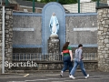 Mayo supporters walk past a Virgin Mary statue, at the Shrine of Wishes, before the All Ireland SFC final